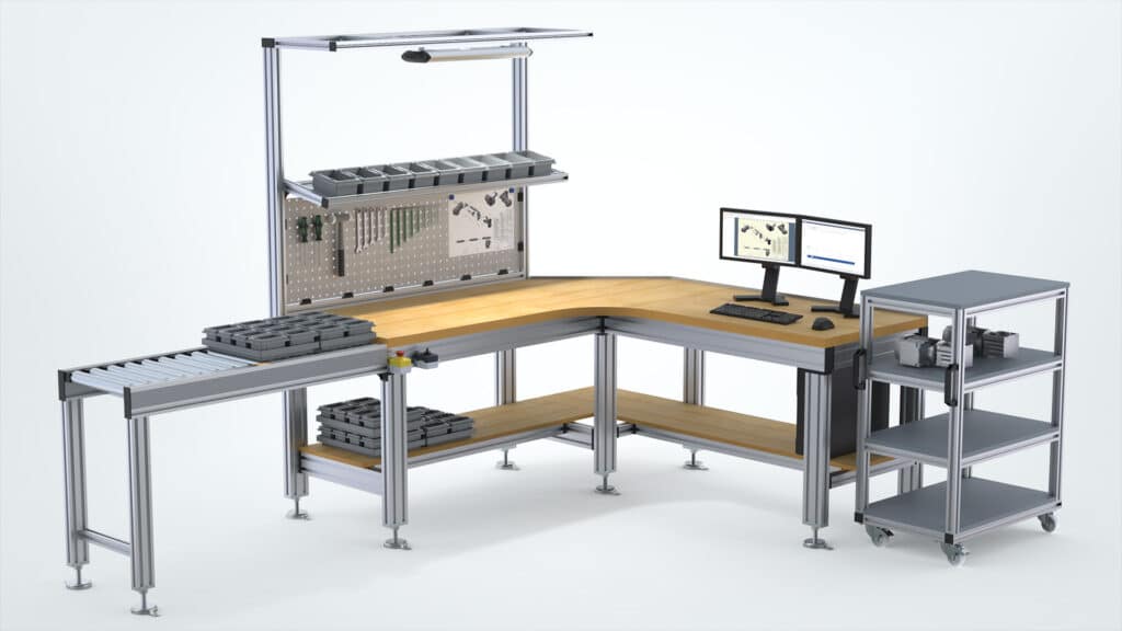 Modularer, ergonomischer Arbeitsbereich von Robotunits mit Eckarbeitstisch, integrierter Werkzeugwand, LED-Beleuchtung und individuell anpassbarer Materialbereitstellung. Ausgestattet mit Rollenbahn für effiziente Materialzufuhr, flexiblen Ablageflächen, einem mobilen Regalsystem sowie einem digitalen Arbeitsplatz mit zwei Monitoren. Ideal für optimierte Montage- und Produktionsprozesse.